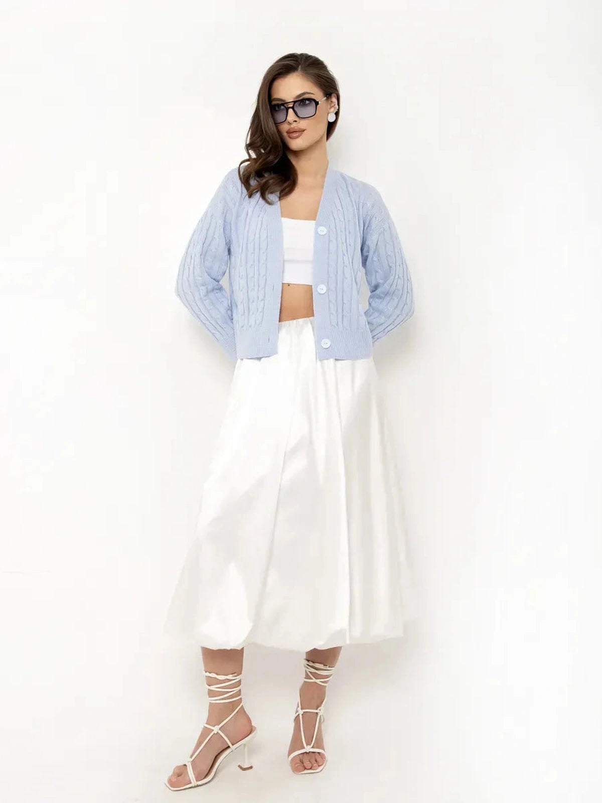Aurelia Cardigan by Lauven in light blue, cropped knit with button closure, styled with white skirt and sandals.