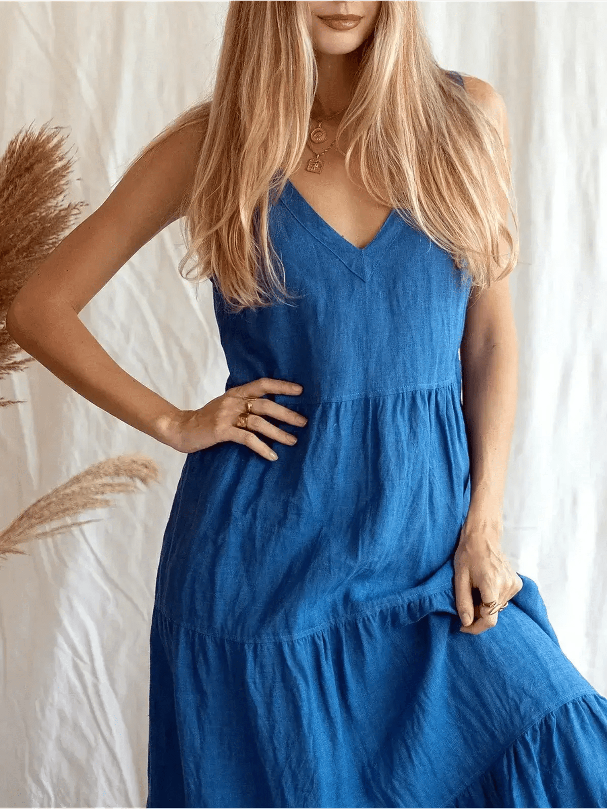 Model wearing the Azure Grace Maxi Dress in blue, showcasing its sleeveless design and tiered skirt.