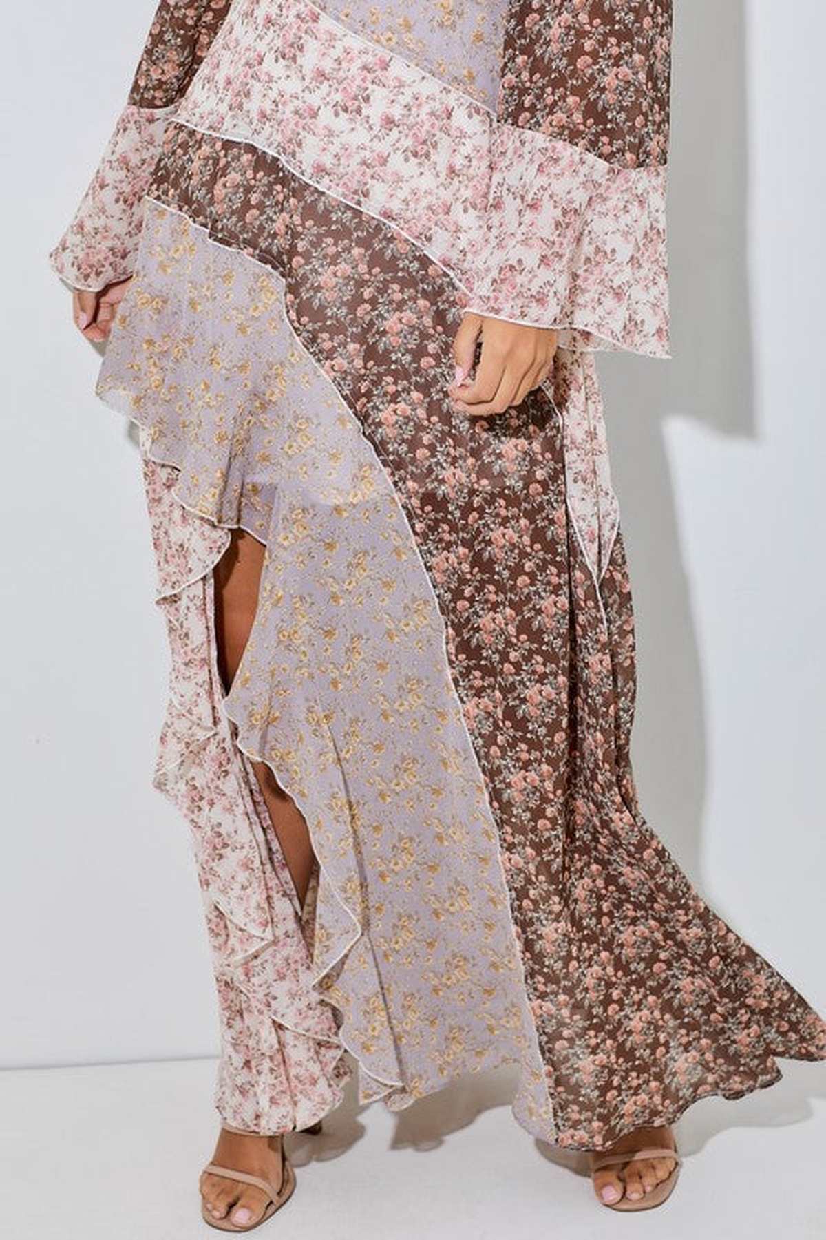 Celeste maxi dress featuring a floral patchwork design, ruffle trim, and asymmetrical hem for bohemian elegance.