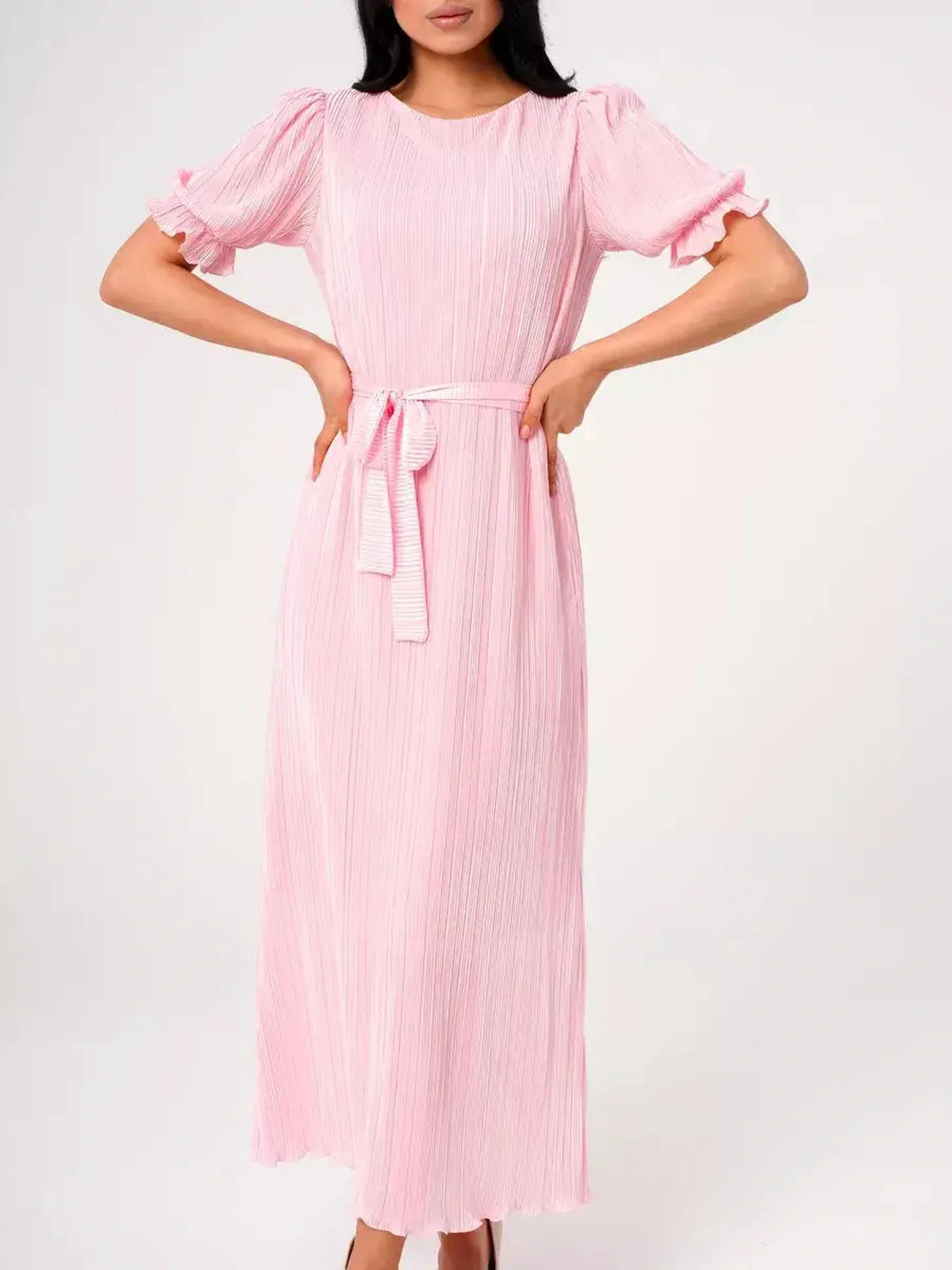 Celeste Maxi Dress in soft pink, featuring pleated fabric, puff sleeves, and a stylish tie waist for a feminine look.