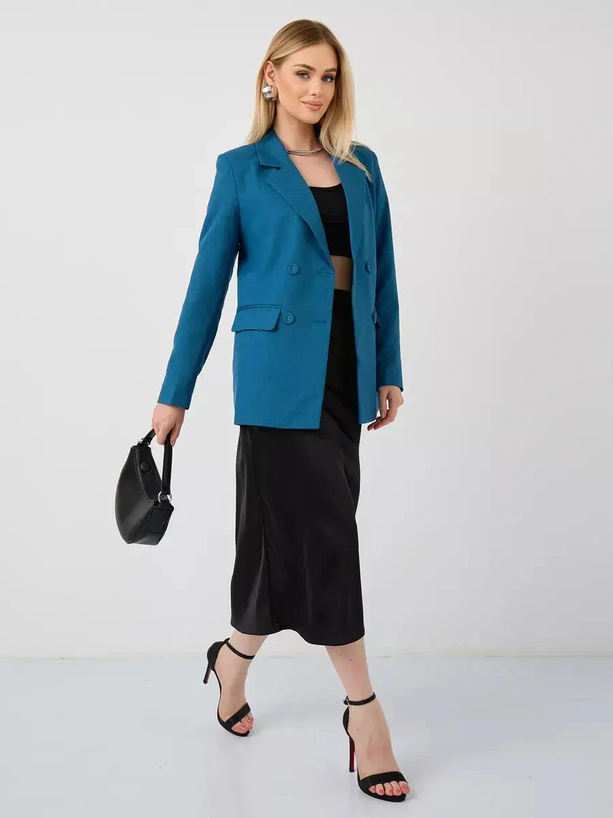 Diana Blazer by Lauven, a cropped teal blazer worn with a black skirt and sandals, showcasing timeless elegance.