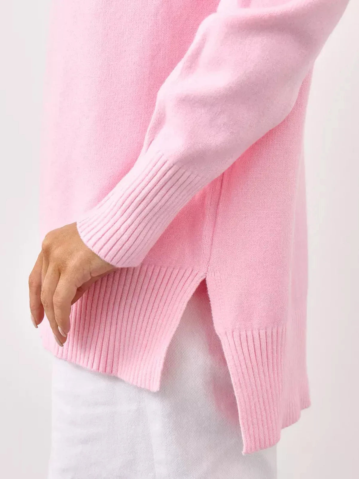 Close-up of Lauven Rosette Sweater, oversized pink cashmere knitwear showcasing ribbed details and side slits.