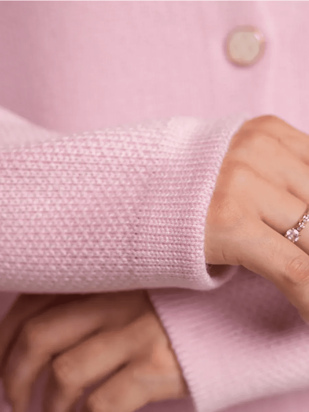 Blush Cardigan by Lauven showing a close-up of the textured sleeve and decorative button in soft pink knit.