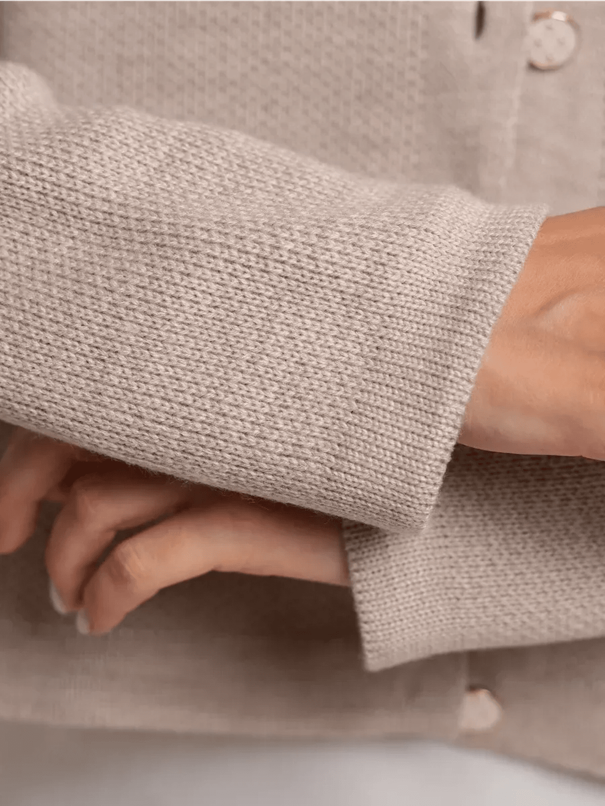Close-up of Alba Cardigan by Lauven showing beige knit texture and decorative buttons.