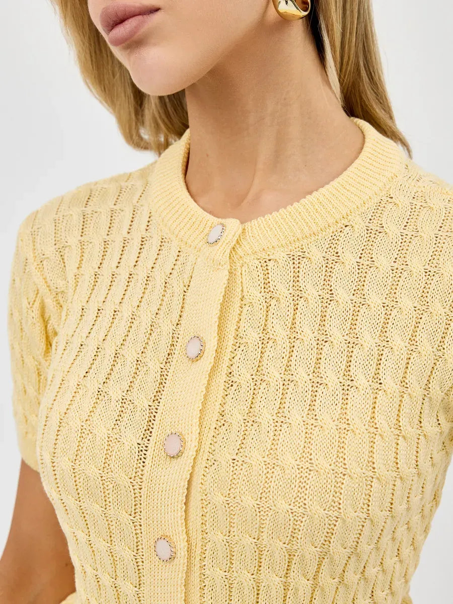 Close-up of a woman wearing the Solara Cardigan in soft yellow, showcasing breathable knitwear by Lauven.