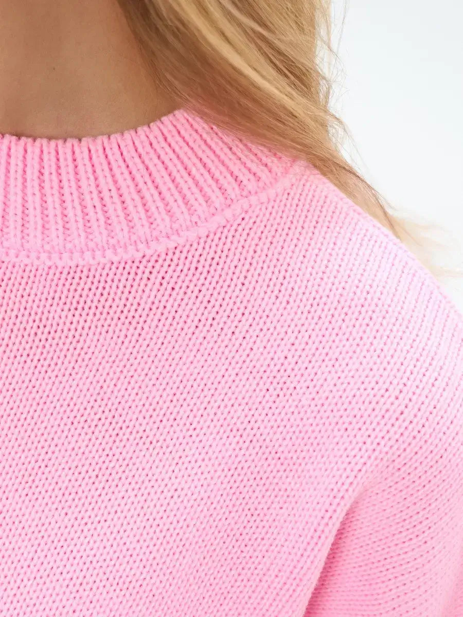 Close-up of the neckline of the Candy Sweater by Lauven in soft pink, showcasing its cozy knit texture and design.