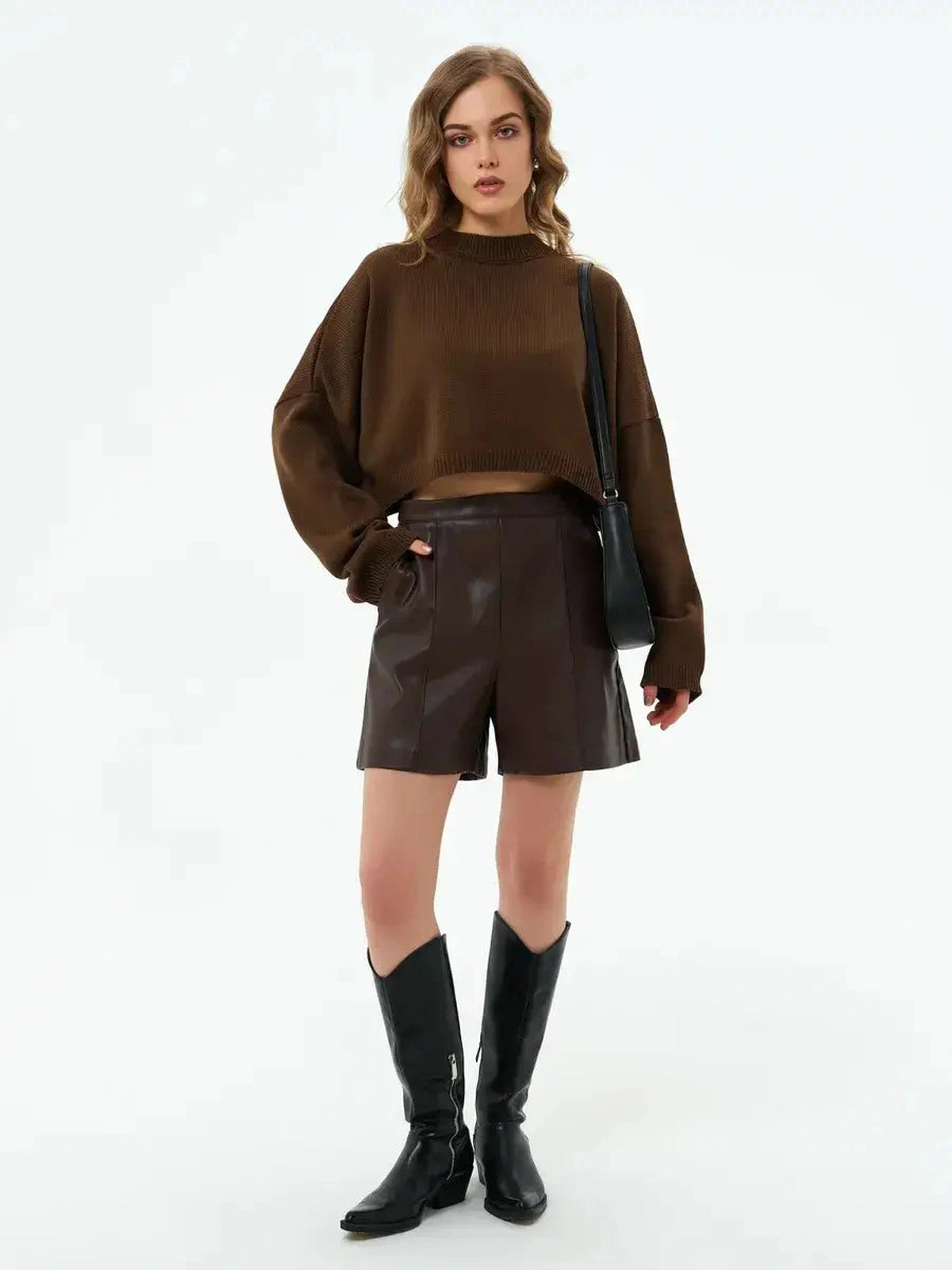 Model wearing the Mocha Sweater by Lauven with brown shorts and boots, showcasing a stylish oversized cropped look.