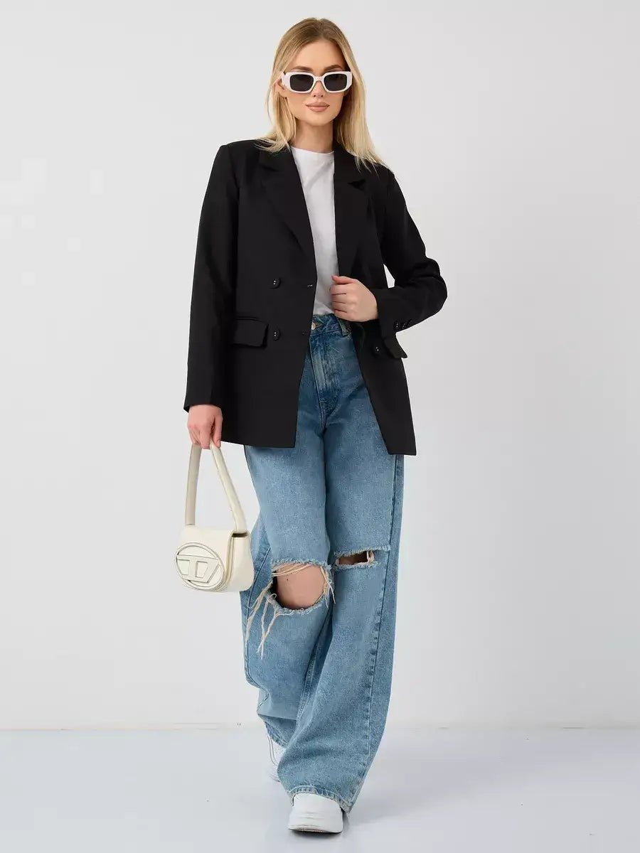 Model wearing the Nova Blazer by Lauven, featuring an oversized black double-breasted design paired with casual jeans.