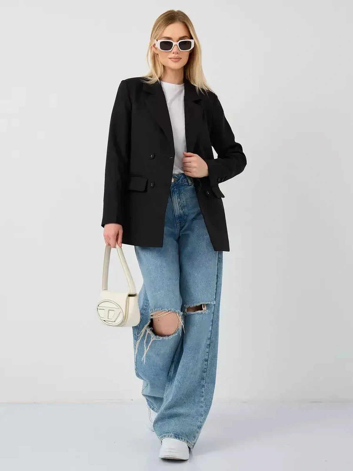 Model wearing the Nova Blazer by Lauven, featuring an oversized black double-breasted design paired with casual jeans.