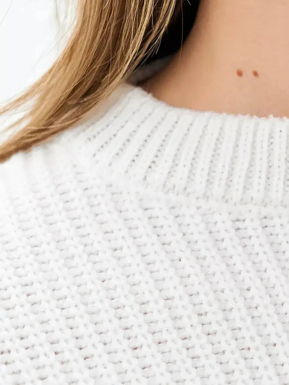 Close-up of Nova Sweater by Lauven, featuring a rib-knit texture and soft white color for cozy elegance.