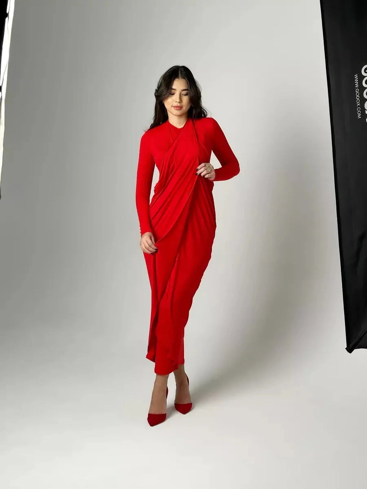 Model showcasing the Sculpted Grace Maxi Dress in red, featuring luxe draping and a flattering silhouette.