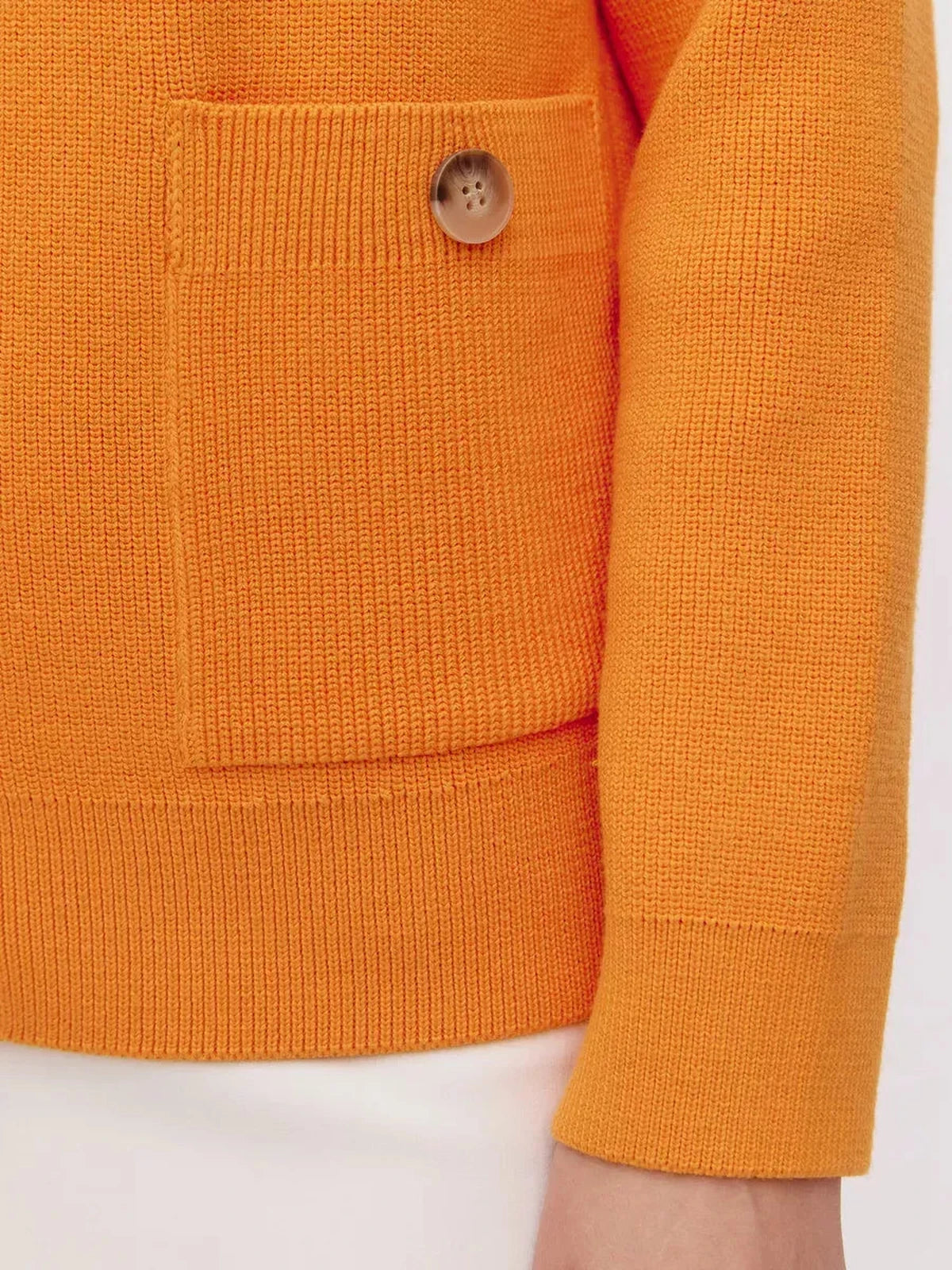 Solana Cardigan by Lauven featuring a vibrant orange knit detail and buttoned pocket for modern elegance.