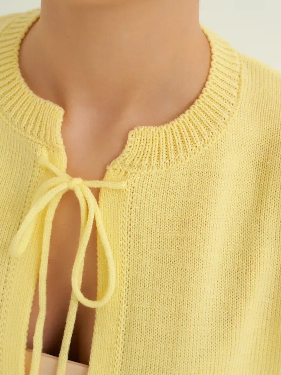 Close-up of the Solara Cardigan by Lauven, showcasing the tie-front detail in a vibrant lemon-yellow knit.