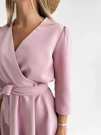 Close-up of a woman wearing a pink mini dress with a V-neckline and fitted waist, showcasing elegance and style.