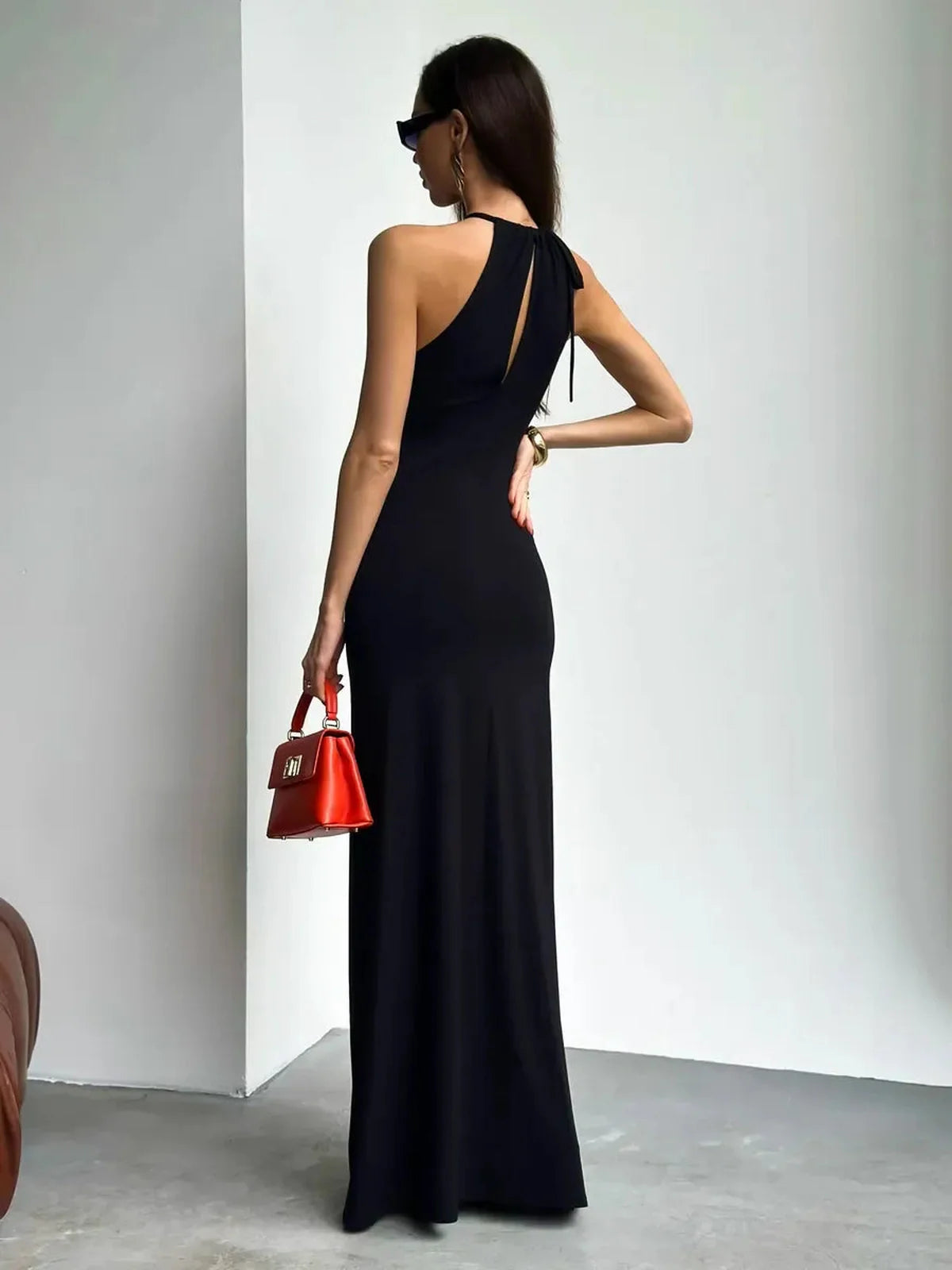 Elegant black maxi dress featuring a ruched halter neckline, back keyhole, and figure-flattering design.