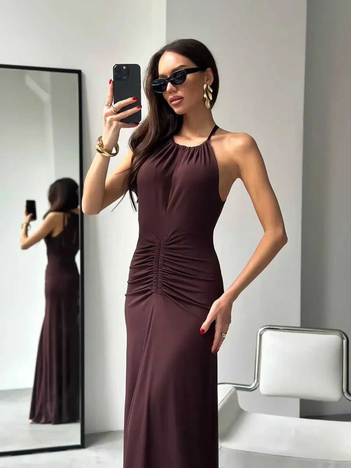 Model in a stylish Maxi Dress Sienna showcasing a ruched silhouette and high halter neckline in rich sienna.