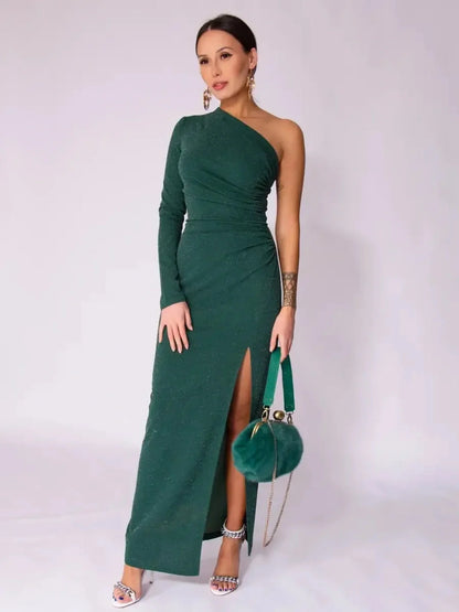 Model showcasing the Emerald Spark Maxi Dress in rich green with a one-shoulder design and side slit for elegance.