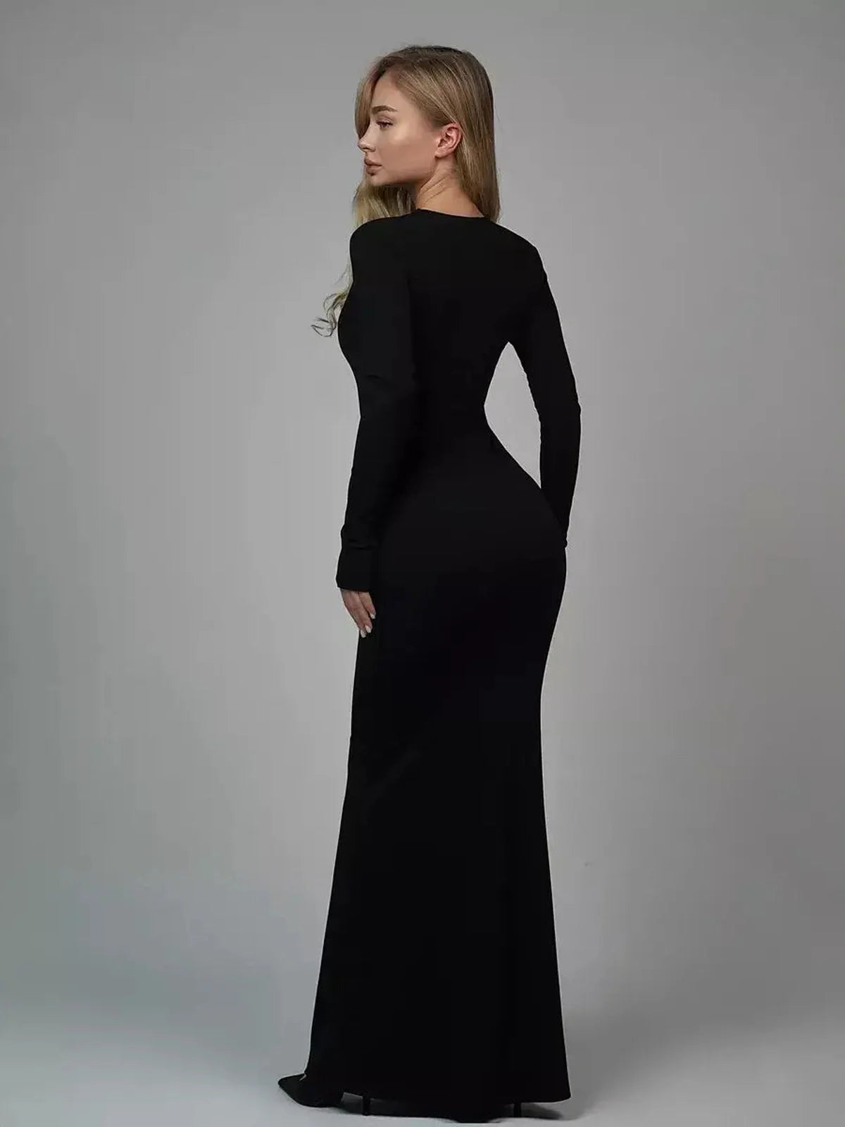 Back view of a woman in a black Sculpted Elegance Maxi Dress, showcasing a sleek and seamless silhouette.