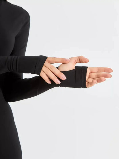 Close-up of a woman's hands showing thumb hole detail on long sleeve black dress for a chic, modern look.