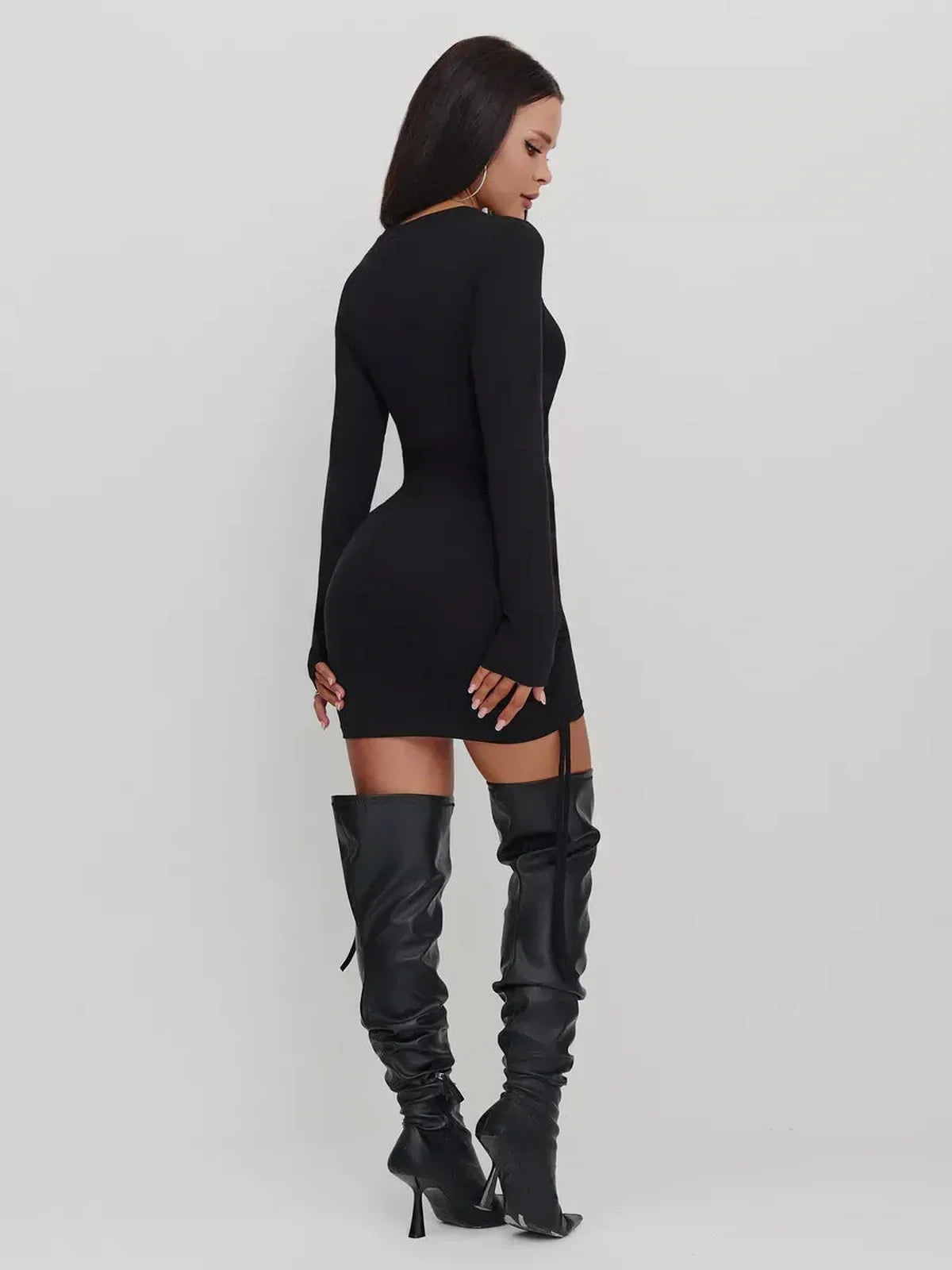 Back view of a black long sleeve midi dress, tailored for a flattering silhouette and styled with knee-high boots.