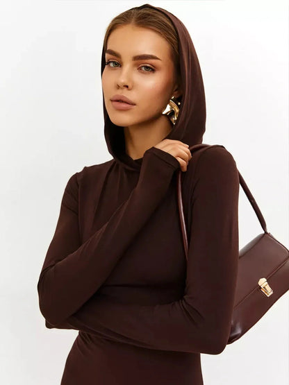 Model wearing a hooded Sculpt Maxi Dress in chocolate with a sleek silhouette, showcasing modern elegance.