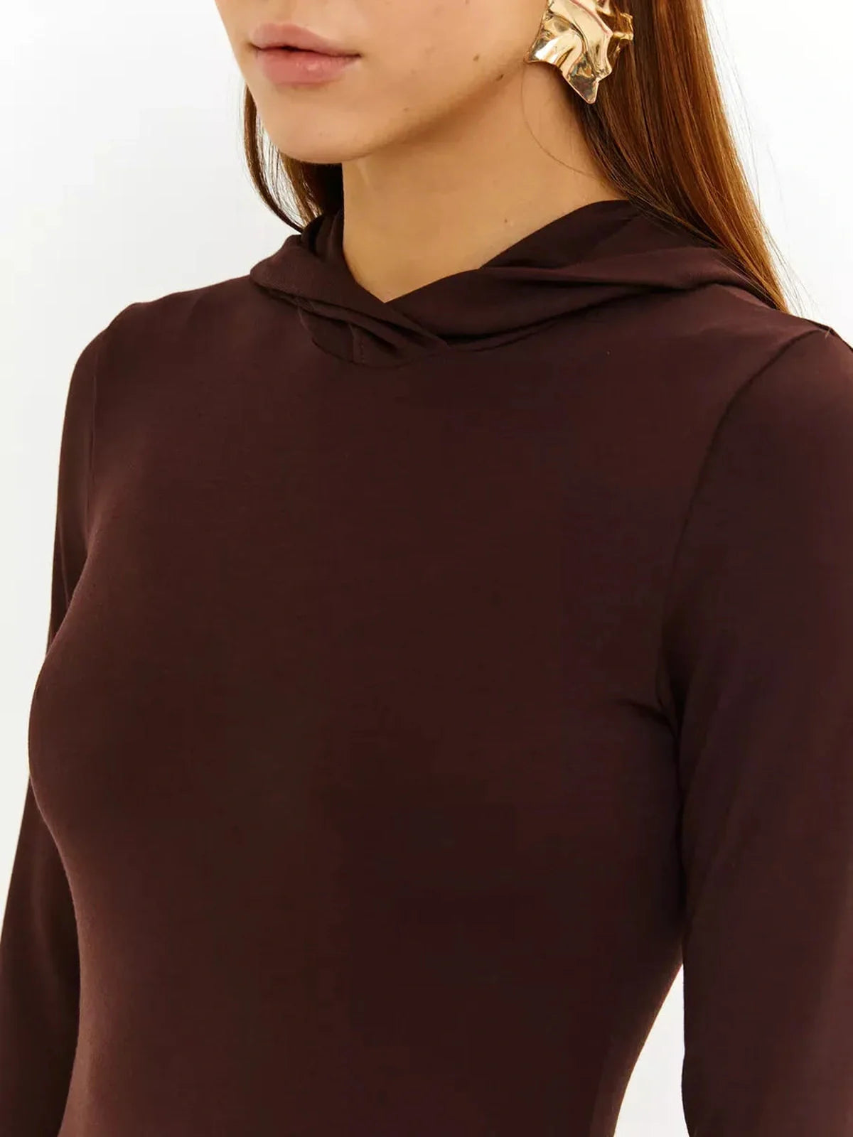 Close-up of a model wearing the Sculpt Maxi Dress in rich chocolate, showcasing the hood and elegant silhouette.