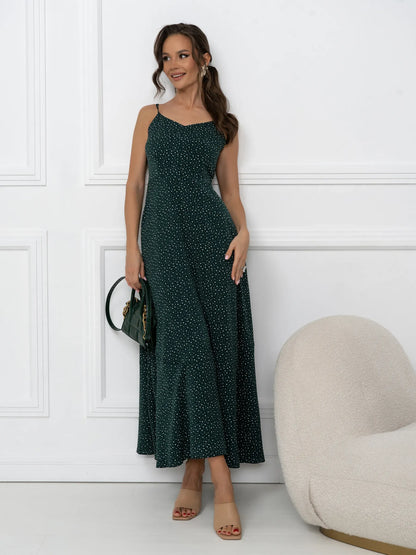 Model wearing an emerald green maxi dress with a dotted print and open-back tie detail, perfect for summer events.