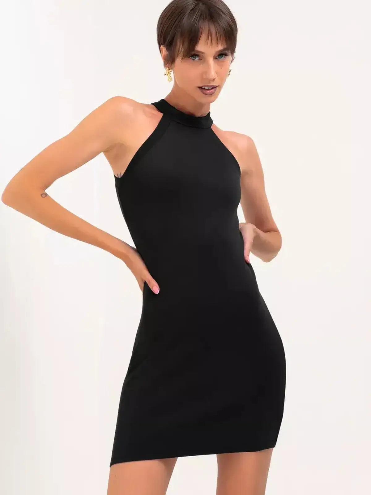Model showcasing a sleek black mini dress with a halter neckline, perfect for evening events and cocktail parties.