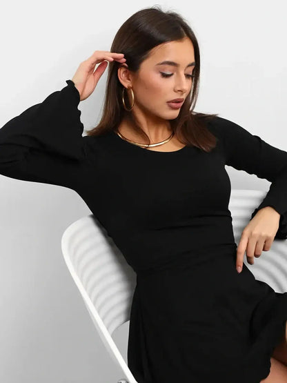 Model showcasing the Noir Laced black mini dress with flared sleeves and U-neckline, perfect for cocktail occasions.