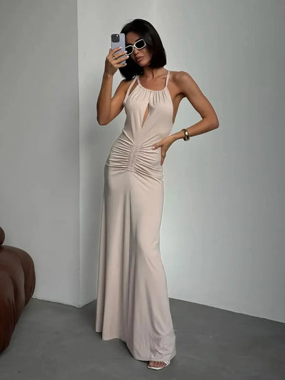 Model wearing the Serene Curve Maxi Dress showcasing ruched detailing and a halter neckline in a chic indoor setting.