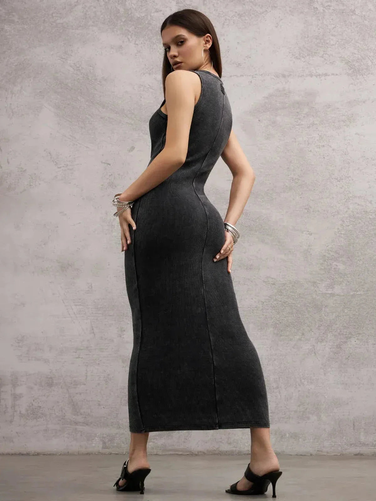 Model showcasing the Shadow Curve Maxi Dress in graphite, highlighting its sleeveless design and bodycon fit.