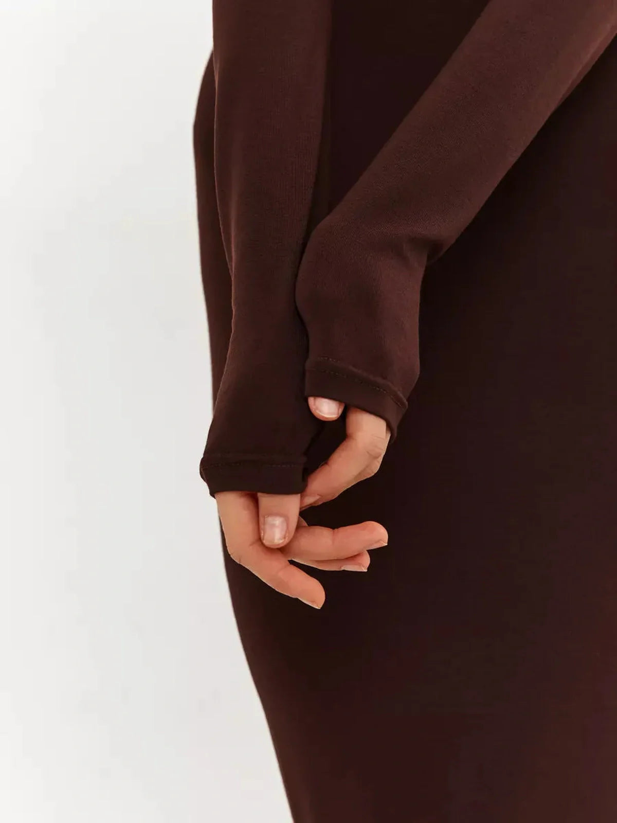 Close-up of hands in long sleeves of a chocolate-toned Sculpt Maxi Dress, showcasing soft knit and sleek design.