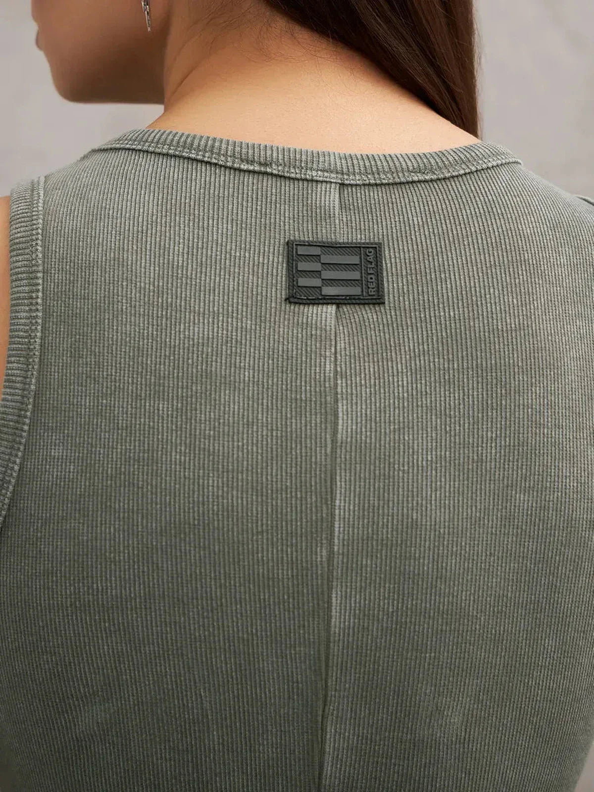 Close-up of the back of the Verdant Curve Maxi Dress in washed khaki showcasing its rib knit texture and logo detail.
