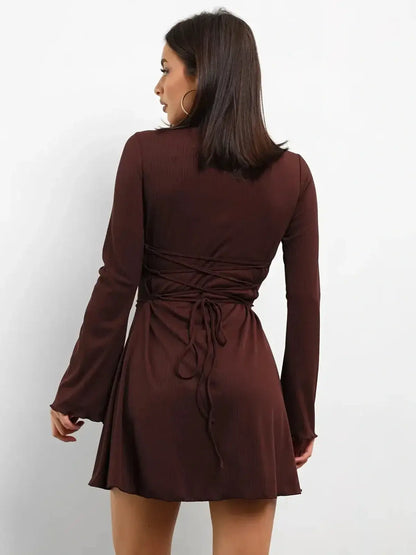 Cocoa Laced mini dress with adjustable lace-up back and flared long sleeves, perfect for cocktail or wedding guest attire.