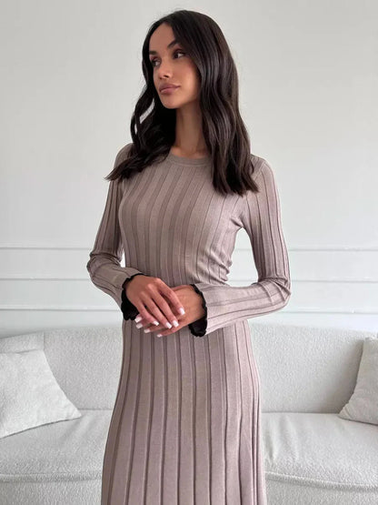 Model showcasing the Contour Maxi Dress in ribbed knit, featuring a long silhouette and elegant ruffle hem.