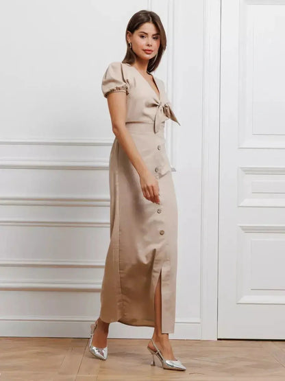 Model wearing the Serene Bond Maxi Dress with puff sleeves and waist tie, showcasing its elegant design in a neutral tone.