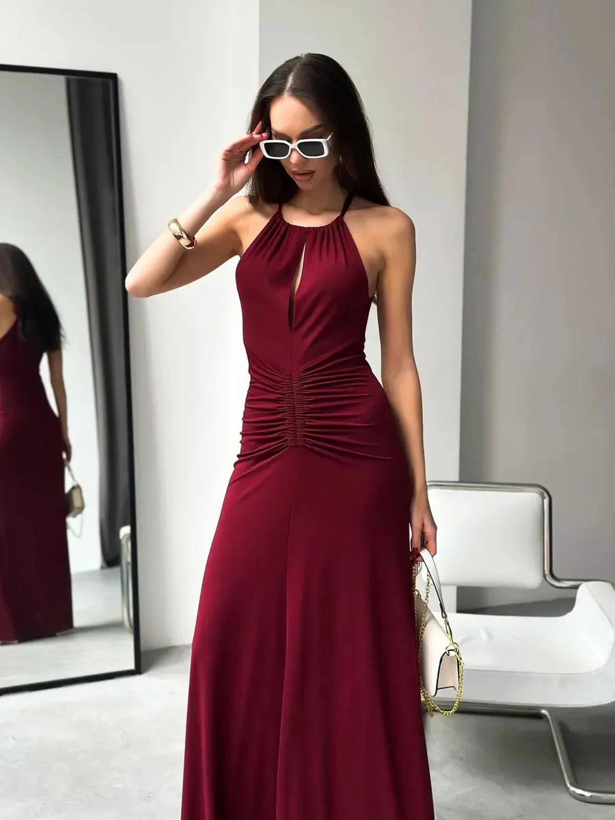 Model in burgundy Maxi Dress Élan, showcasing a halter neck and ruched waist, perfect for elegant evening wear.