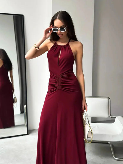 Model in burgundy Maxi Dress Élan, showcasing a halter neck and ruched waist, perfect for elegant evening wear.