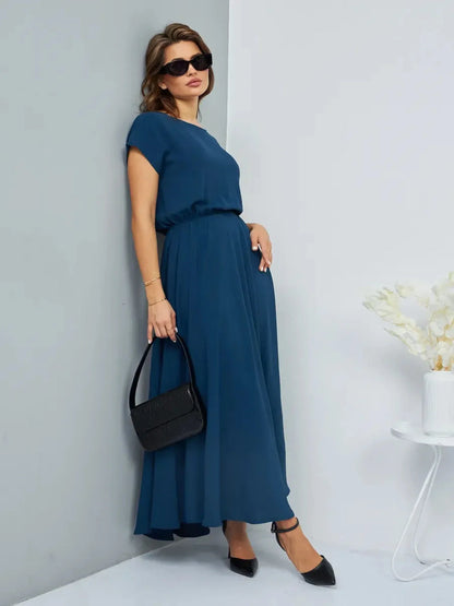 Woman in a teal Verona Maxi Dress with pockets, accessorized with sunglasses and a black handbag, exuding summer elegance.