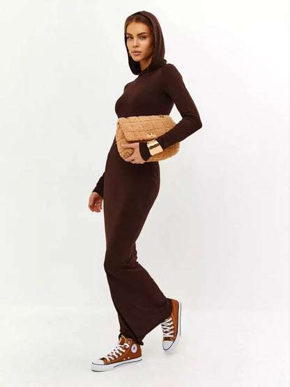 Woman in a brown hooded Sculpt Maxi Dress, styled with a clutch and sneakers, showcasing a sleek, elegant look.