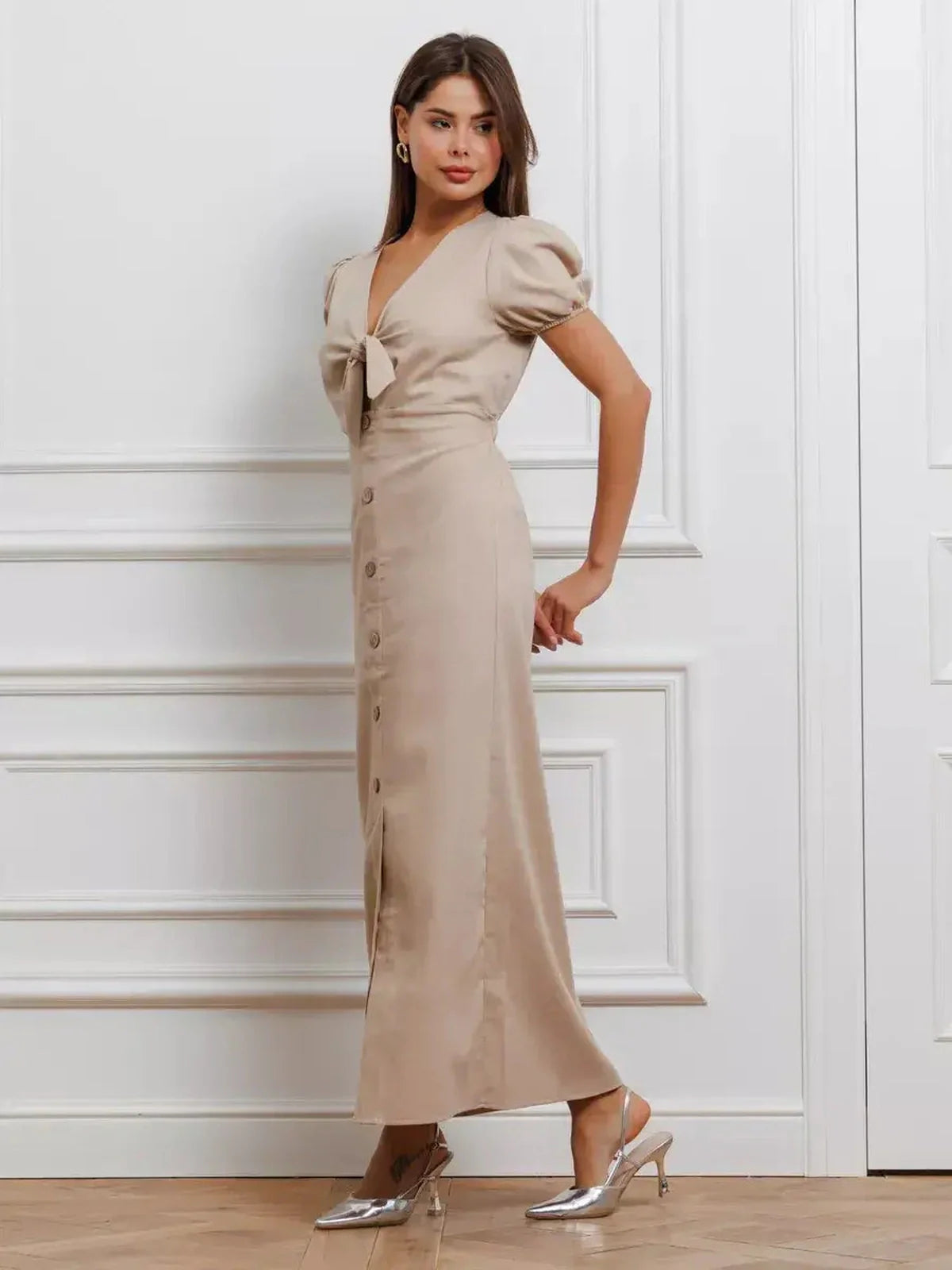 Model wearing the Serene Bond Maxi Dress with refined puff sleeves and waist tie in a soft neutral hue.