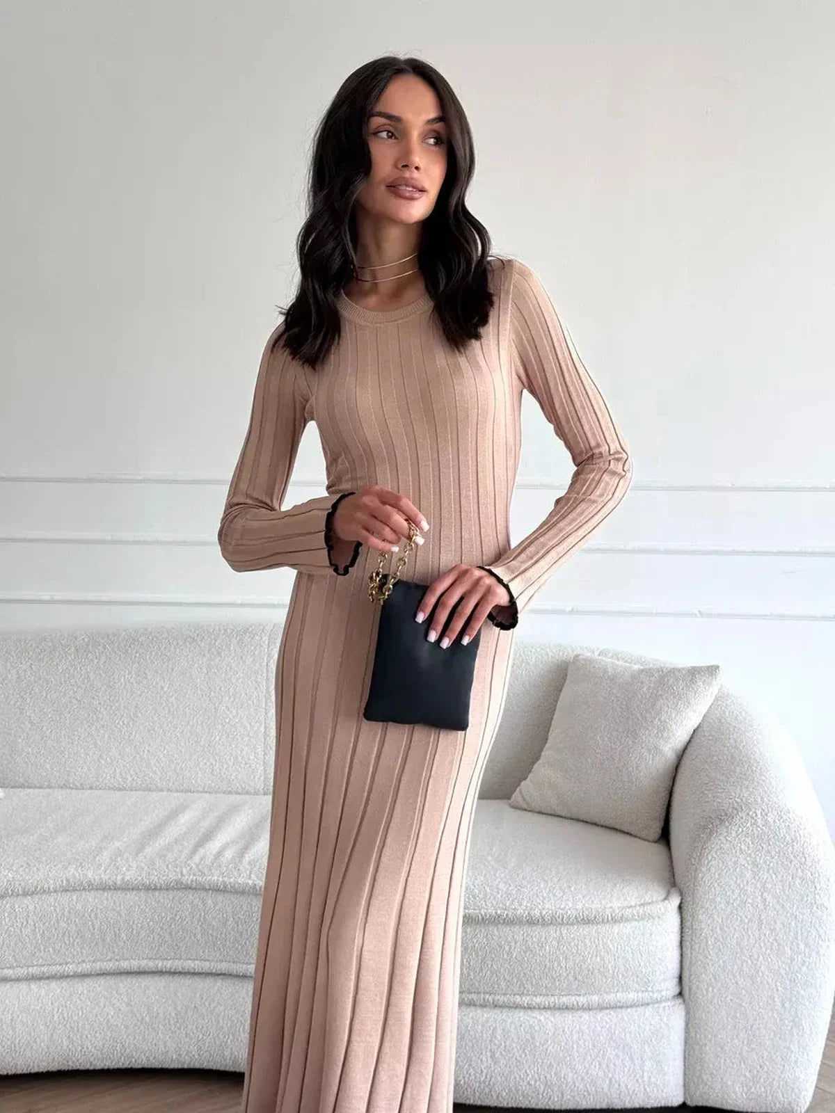 Model wearing the Sahara Curve Maxi Dress in sandstone beige, showcasing its soft ribbed texture and elegant full-length design.