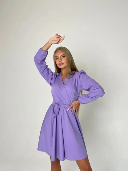 Model showcasing the Lilac Charm mini dress in lavender with a V-neckline and adjustable tie belt.