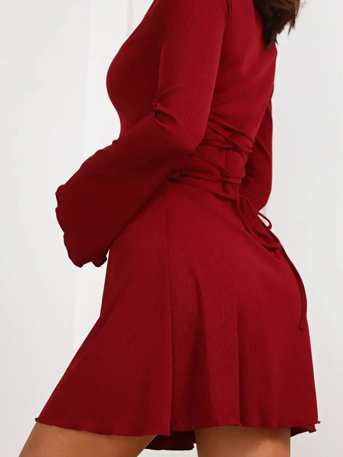 Ruby Laced red mini dress featuring long bell sleeves and corset-style lace-up detail for a bold, elegant look.