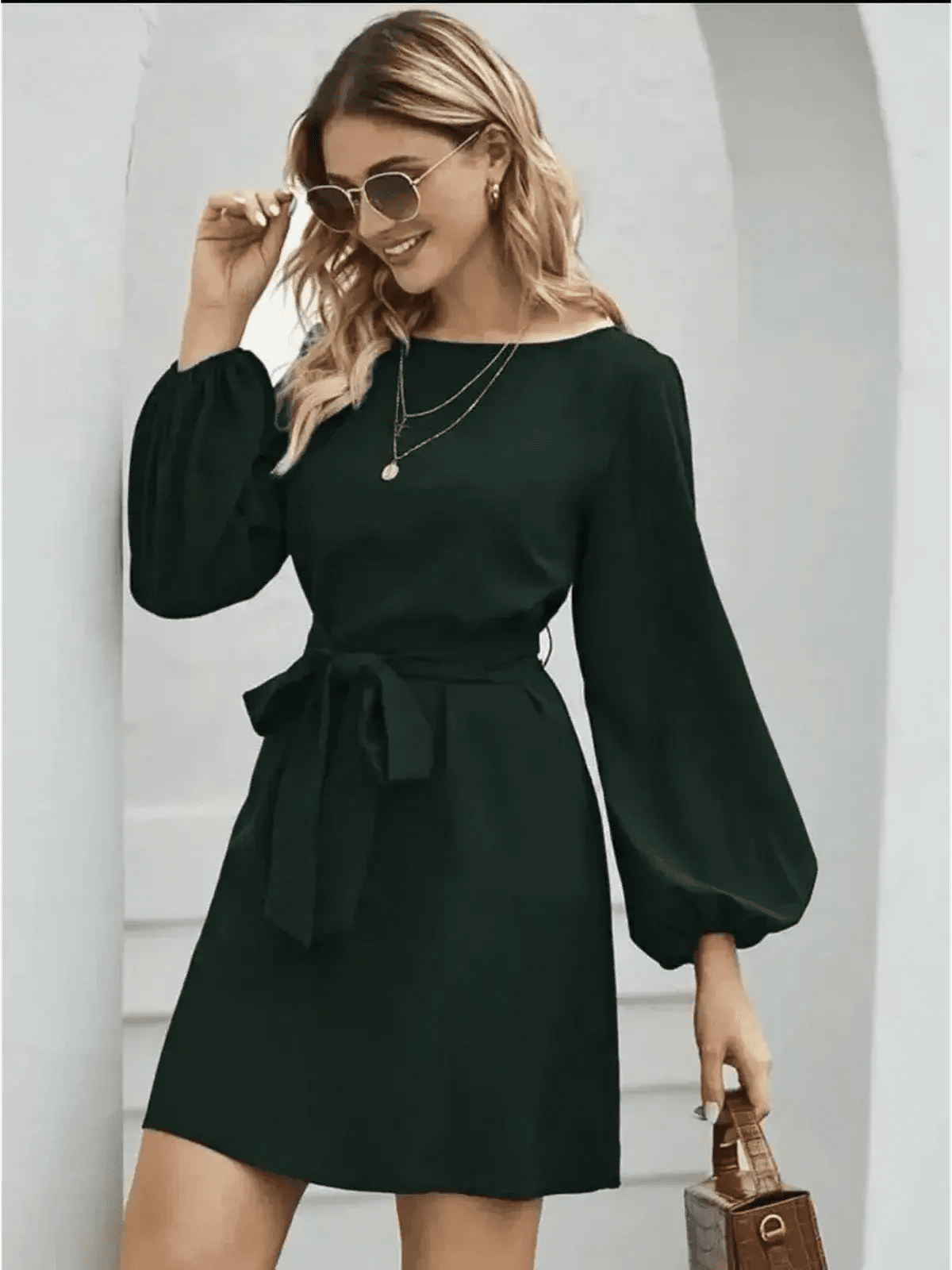 Emerald green mini dress with long sleeves and a tie waist, perfect for wedding guest or cocktail attire.