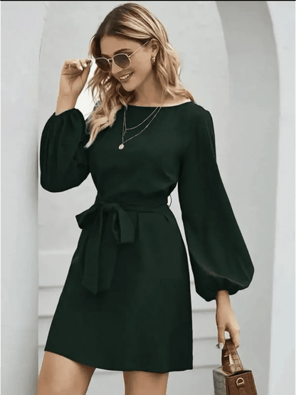 Emerald green mini dress with long sleeves and a tie waist, perfect for wedding guest or cocktail attire.