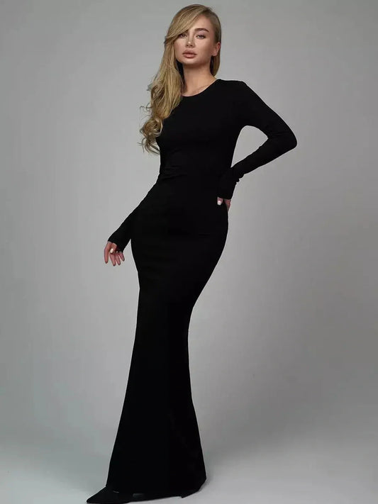 Model showcasing the Sculpted Elegance Maxi Dress in black, featuring long sleeves and a fitted silhouette.