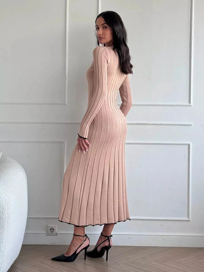 Model showcasing the Sahara Curve Maxi Dress in sandstone beige, featuring a soft ribbed texture and elegant figure-hugging silhouette.