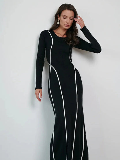Model wearing the Midnight Curve Maxi Dress with elegant white piping, highlighting a flattering silhouette.