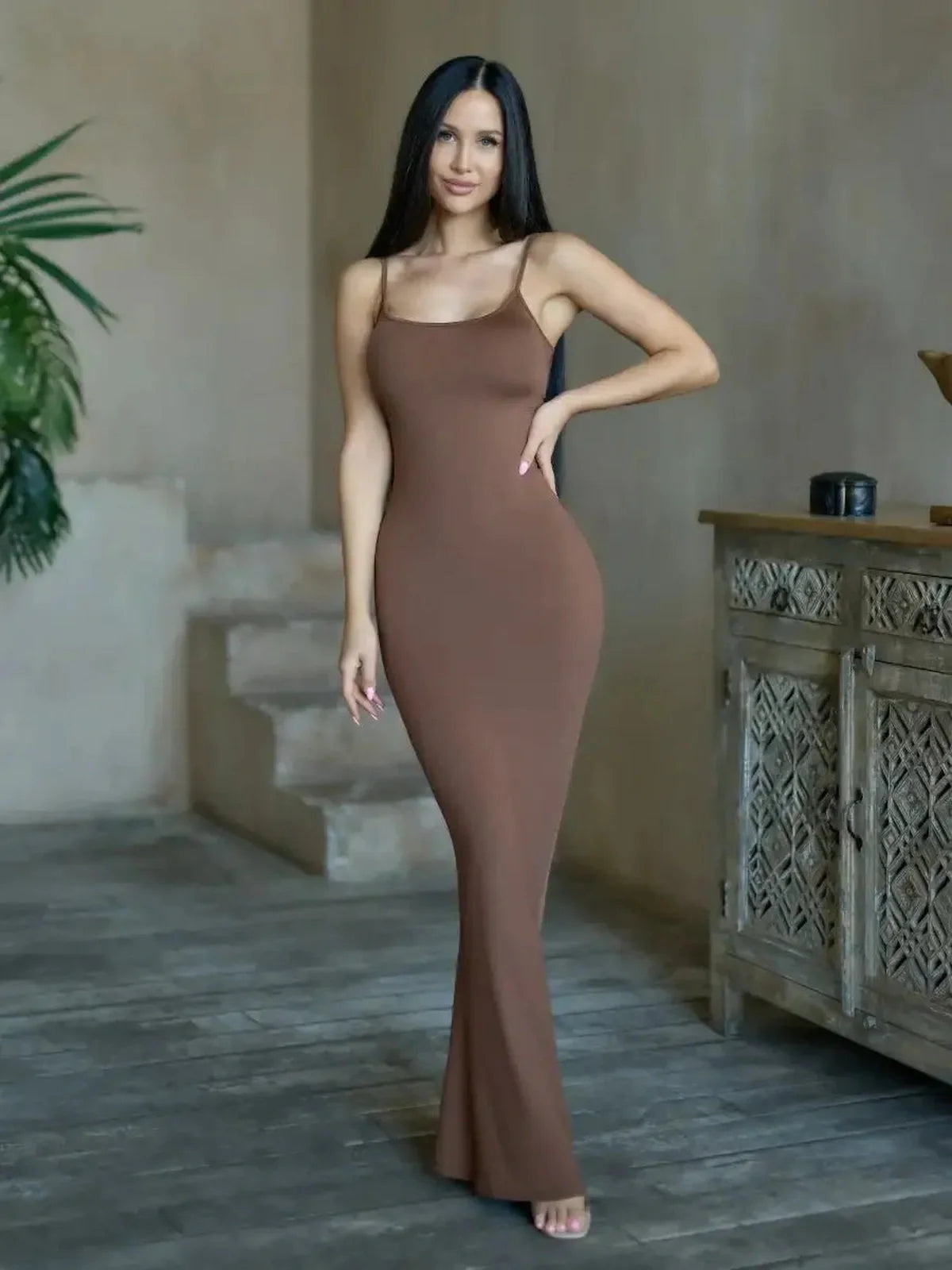 Model wearing Cocoa Curve Maxi Dress in deep brown, showcasing sleek silhouette and minimalistic style.